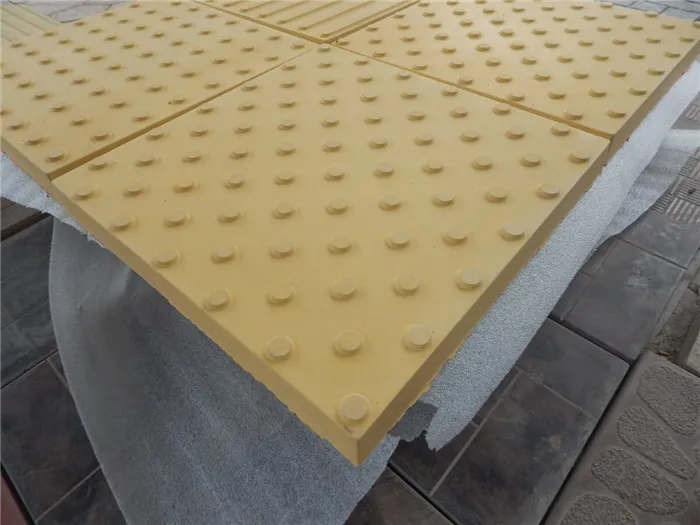 Тактильная плитка с усеченными конусными рифами в шахматном порядке производства компании ЛОБАС