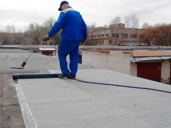 Рабочие ремонтируют крышу гаража